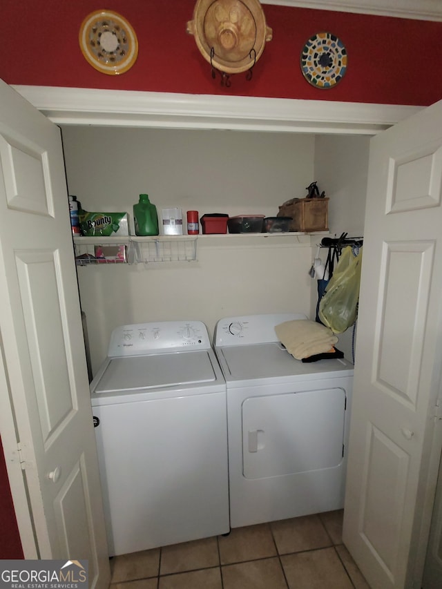 clothes washing area featuring washing machine and dryer and light tile patterned floors