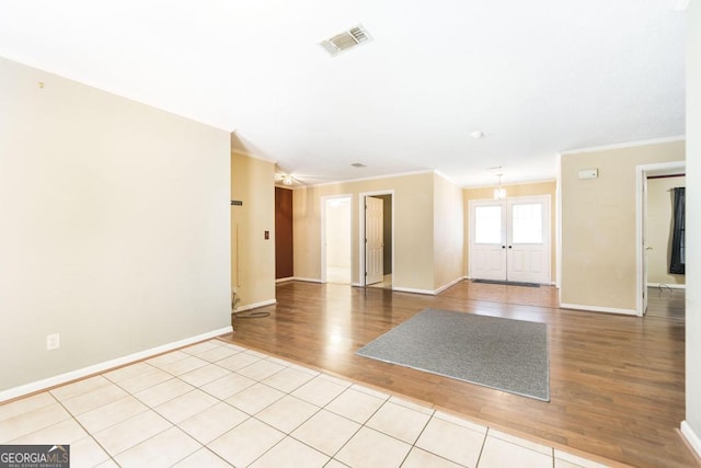 unfurnished room featuring light wood-style flooring, visible vents, baseboards, french doors, and crown molding