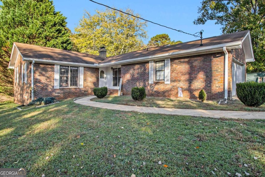 ranch-style home with a garage and a front lawn