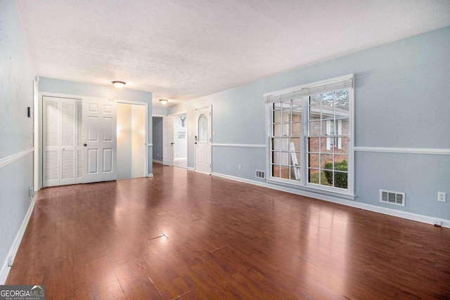 empty room featuring a textured ceiling and hardwood / wood-style flooring