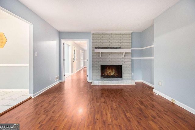 unfurnished living room with wood-type flooring and a fireplace