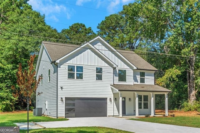 view of front of property with central AC unit, a garage, a front yard, and covered porch