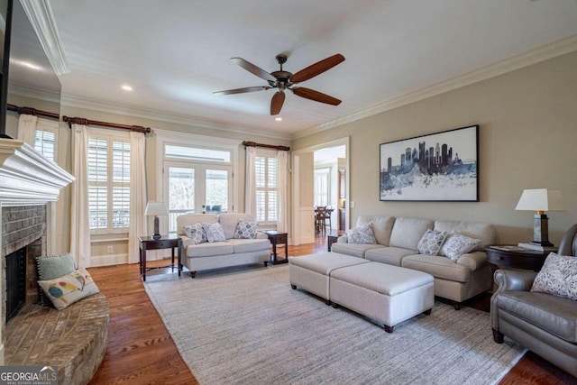 living room featuring wood-type flooring, crown molding, and a brick fireplace