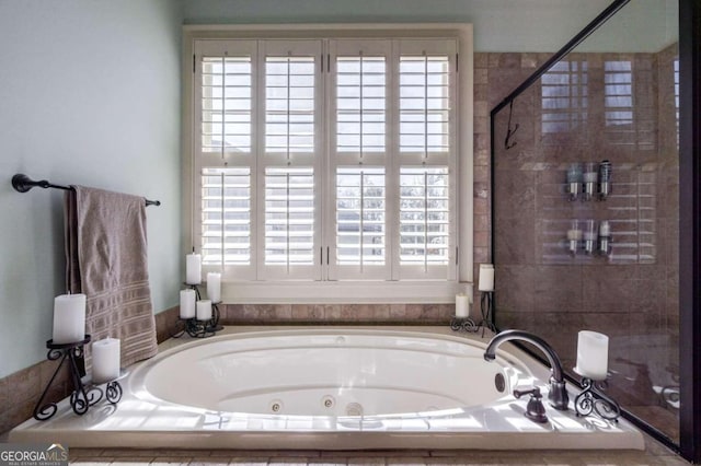 bathroom featuring tiled bath and plenty of natural light