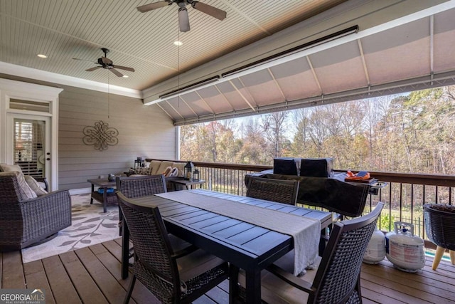 wooden terrace featuring ceiling fan and an outdoor living space