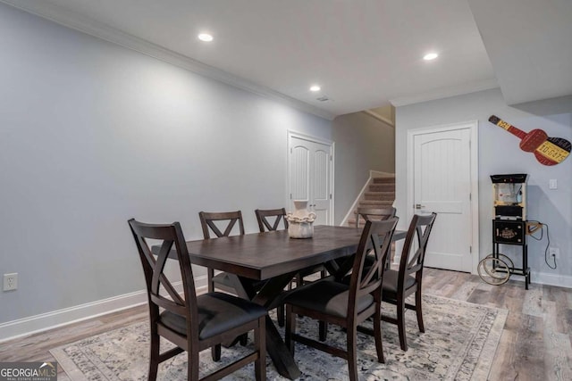 dining space featuring crown molding and light wood-type flooring