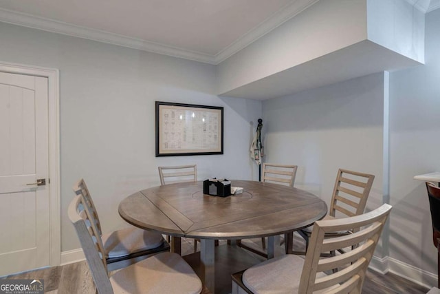 dining area featuring hardwood / wood-style flooring and crown molding