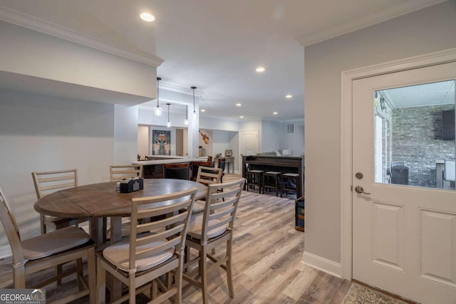 dining area featuring light hardwood / wood-style floors and ornamental molding