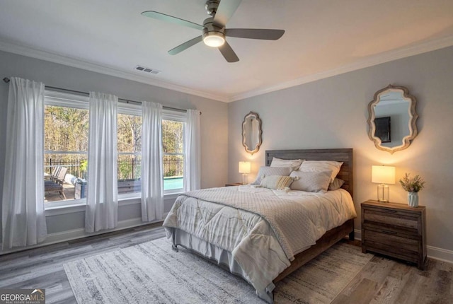 bedroom with hardwood / wood-style floors, ceiling fan, and multiple windows