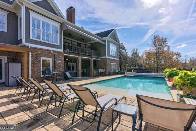 view of swimming pool featuring ceiling fan and a patio area