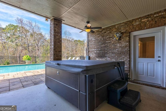 view of patio / terrace featuring ceiling fan and a swimming pool with hot tub