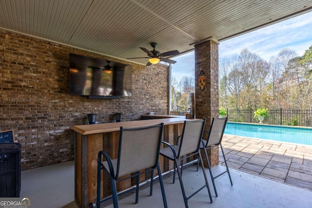 view of patio featuring ceiling fan and exterior bar