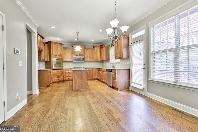 kitchen featuring plenty of natural light, light wood-type flooring, stainless steel appliances, and decorative light fixtures