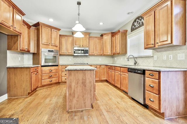 kitchen with a kitchen island, light stone counters, light wood-type flooring, and stainless steel appliances