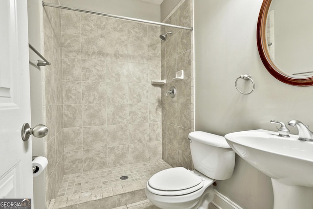 bathroom with sink, toilet, tile patterned flooring, and tiled shower