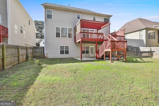 rear view of property featuring a patio, a deck, and a lawn