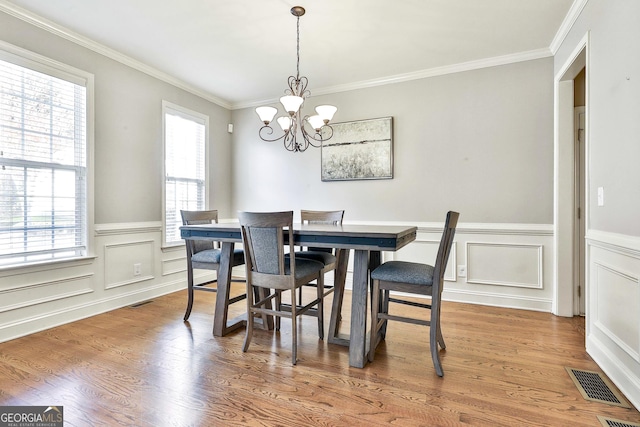 dining area featuring a notable chandelier, plenty of natural light, and wood-type flooring