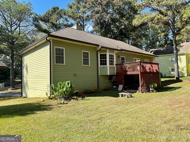 rear view of property with a lawn and a wooden deck