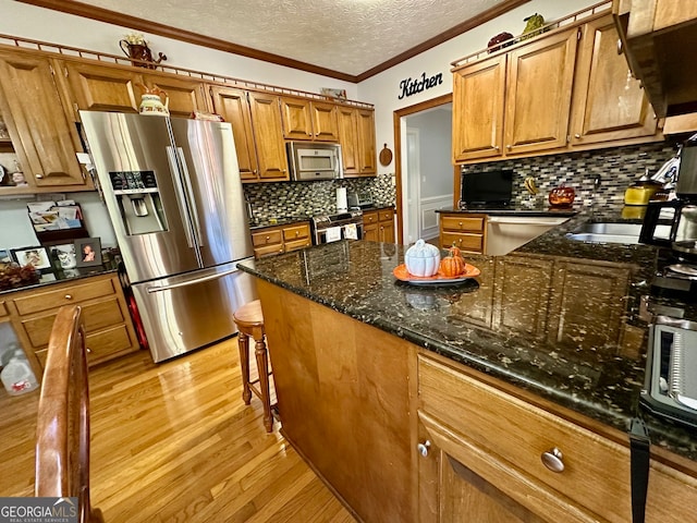 kitchen with appliances with stainless steel finishes, light wood-type flooring, tasteful backsplash, crown molding, and dark stone countertops