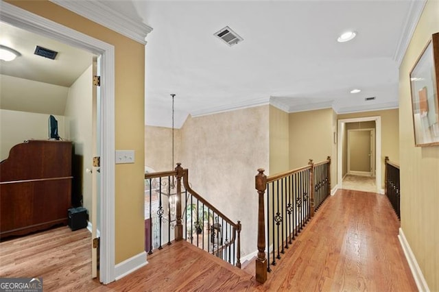 hall with crown molding and light hardwood / wood-style flooring