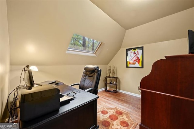 office featuring vaulted ceiling with skylight and light wood-type flooring