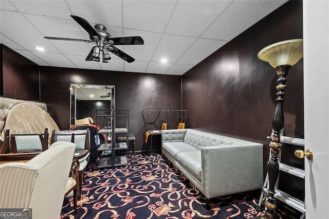 home theater with a paneled ceiling, ceiling fan, and carpet floors