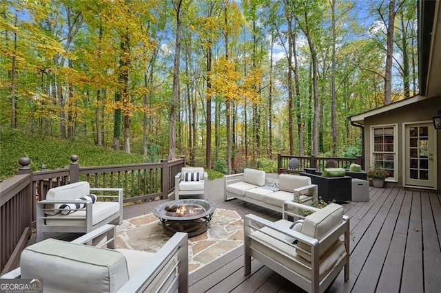 wooden terrace featuring an outdoor living space with a fire pit