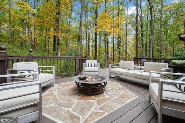 view of patio with a wooden deck and an outdoor living space with a fire pit