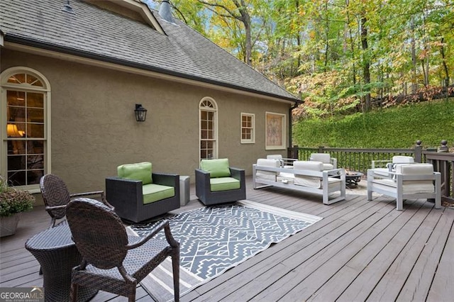 wooden terrace with an outdoor living space