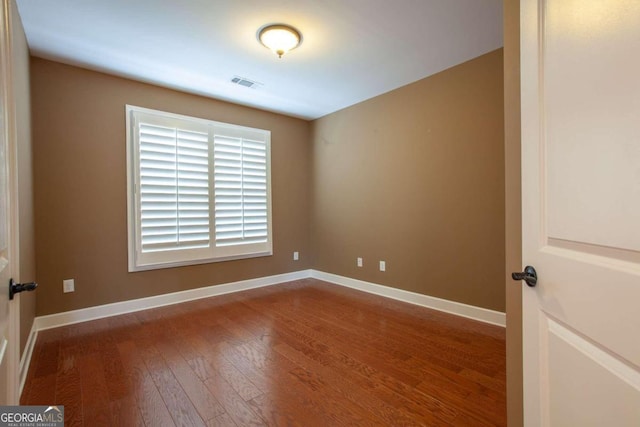 unfurnished room with hardwood / wood-style flooring