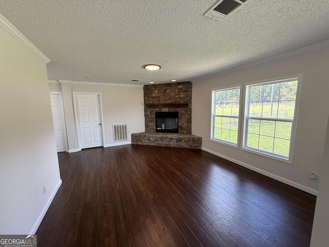 unfurnished living room featuring a textured ceiling, a stone fireplace, dark wood-type flooring, and crown molding