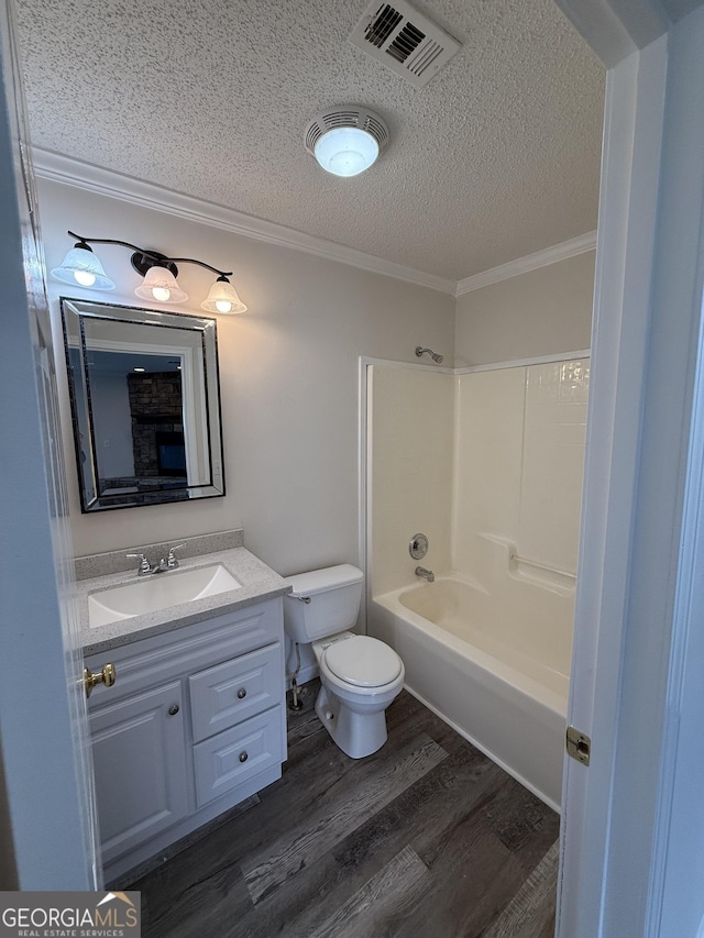 full bathroom featuring crown molding, wood-type flooring, toilet, shower / washtub combination, and vanity