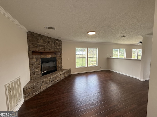 unfurnished living room with crown molding, ceiling fan, a fireplace, a textured ceiling, and dark hardwood / wood-style flooring