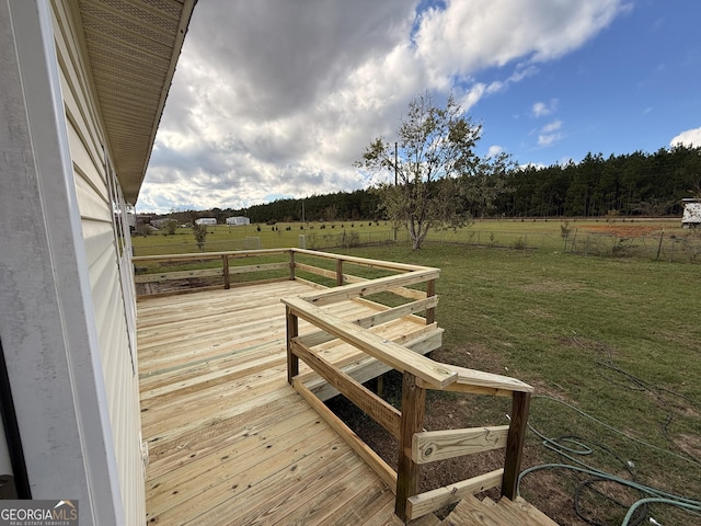 deck with a rural view and a lawn