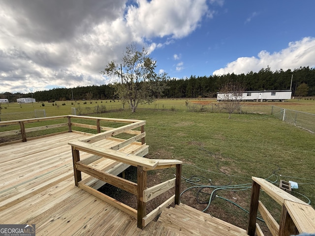 wooden deck featuring a lawn and a rural view