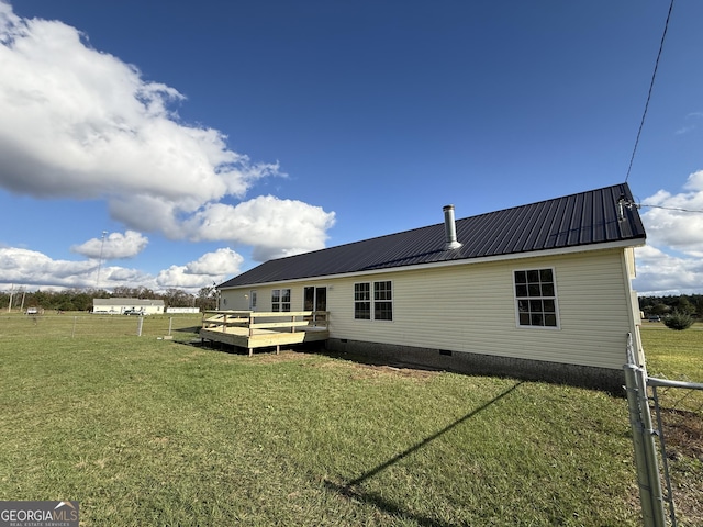 back of house featuring a wooden deck and a yard