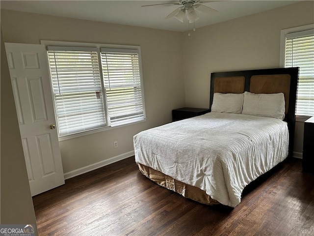 bedroom featuring dark hardwood / wood-style flooring, multiple windows, and ceiling fan