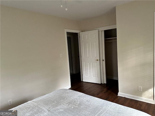 unfurnished bedroom with dark wood-type flooring and a closet