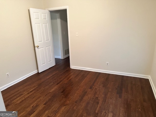 spare room featuring dark wood-type flooring