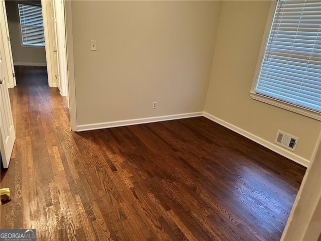 spare room featuring dark wood-type flooring