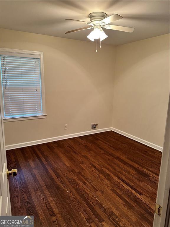 empty room featuring ceiling fan and dark wood-type flooring