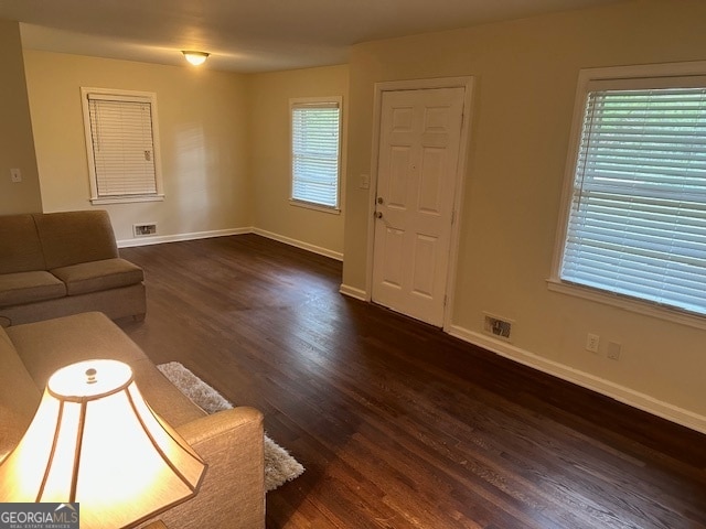 unfurnished living room with dark hardwood / wood-style flooring