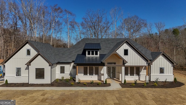 modern inspired farmhouse with board and batten siding, a standing seam roof, roof with shingles, and metal roof