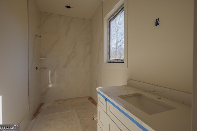 bathroom with a marble finish shower and vanity