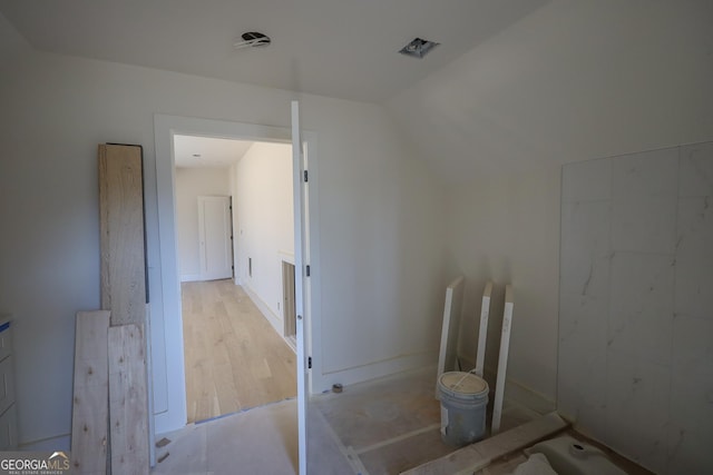 bathroom with vaulted ceiling and wood finished floors