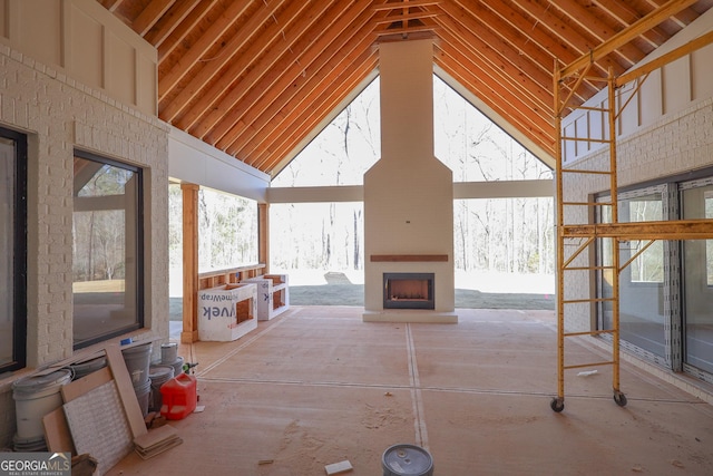 interior space with a large fireplace and high vaulted ceiling