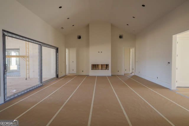 unfurnished living room with high vaulted ceiling