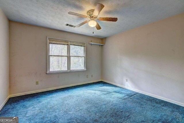 spare room featuring carpet flooring and a textured ceiling