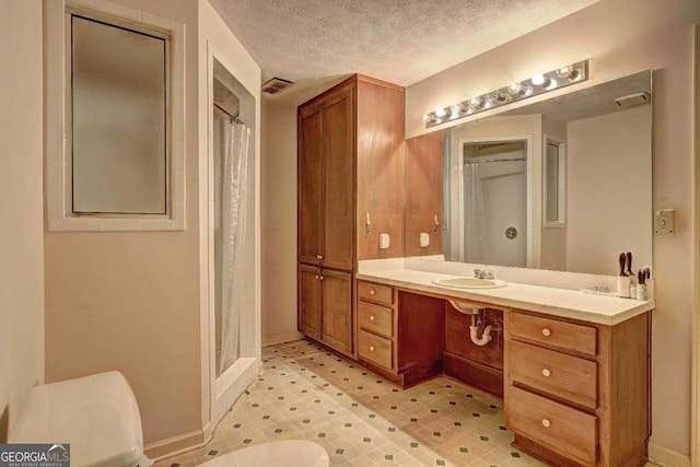 bathroom featuring a shower with curtain, vanity, and a textured ceiling