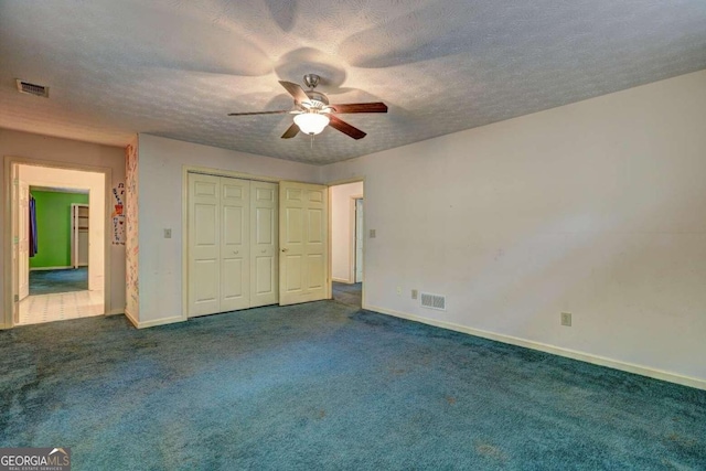 unfurnished bedroom with ceiling fan, a closet, carpet floors, and a textured ceiling